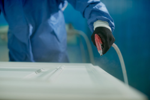 closeup worker spraying timber with spray gun woodworking factory 1