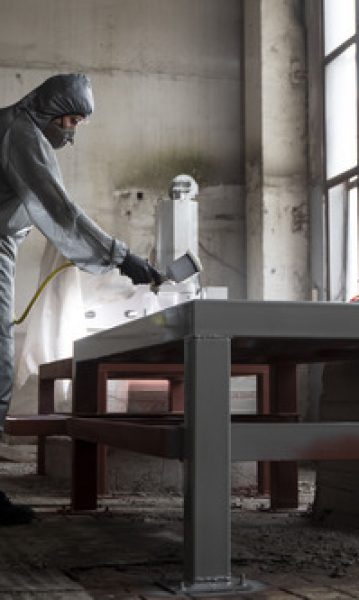 man spraying powder paint from gun full shot 1